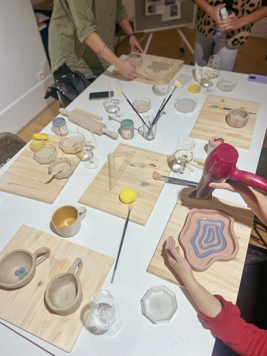 People crafting ceramics at a table.