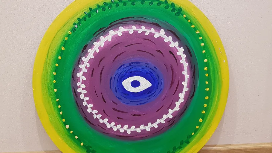 Colorful circular painting with central eye pattern.