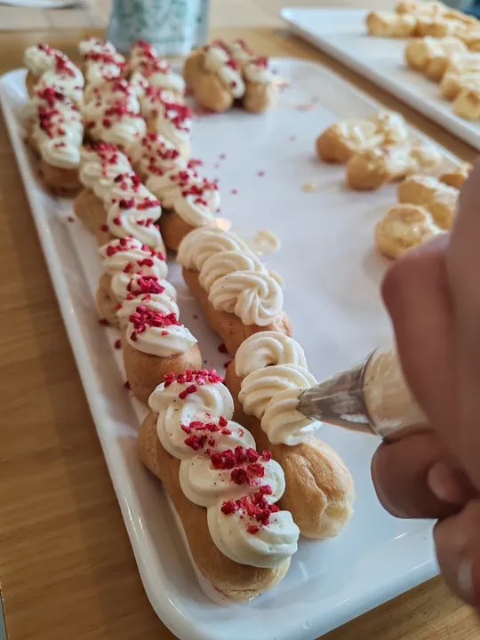 Gebäck mit Sahne und roten Streuseln dekoriert.