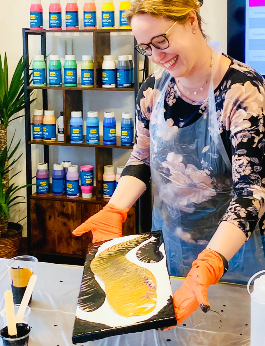 Person hält bemalte Leinwand im Kunststudio.