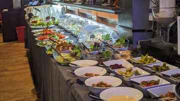 Buffet table with various dishes in restaurant.