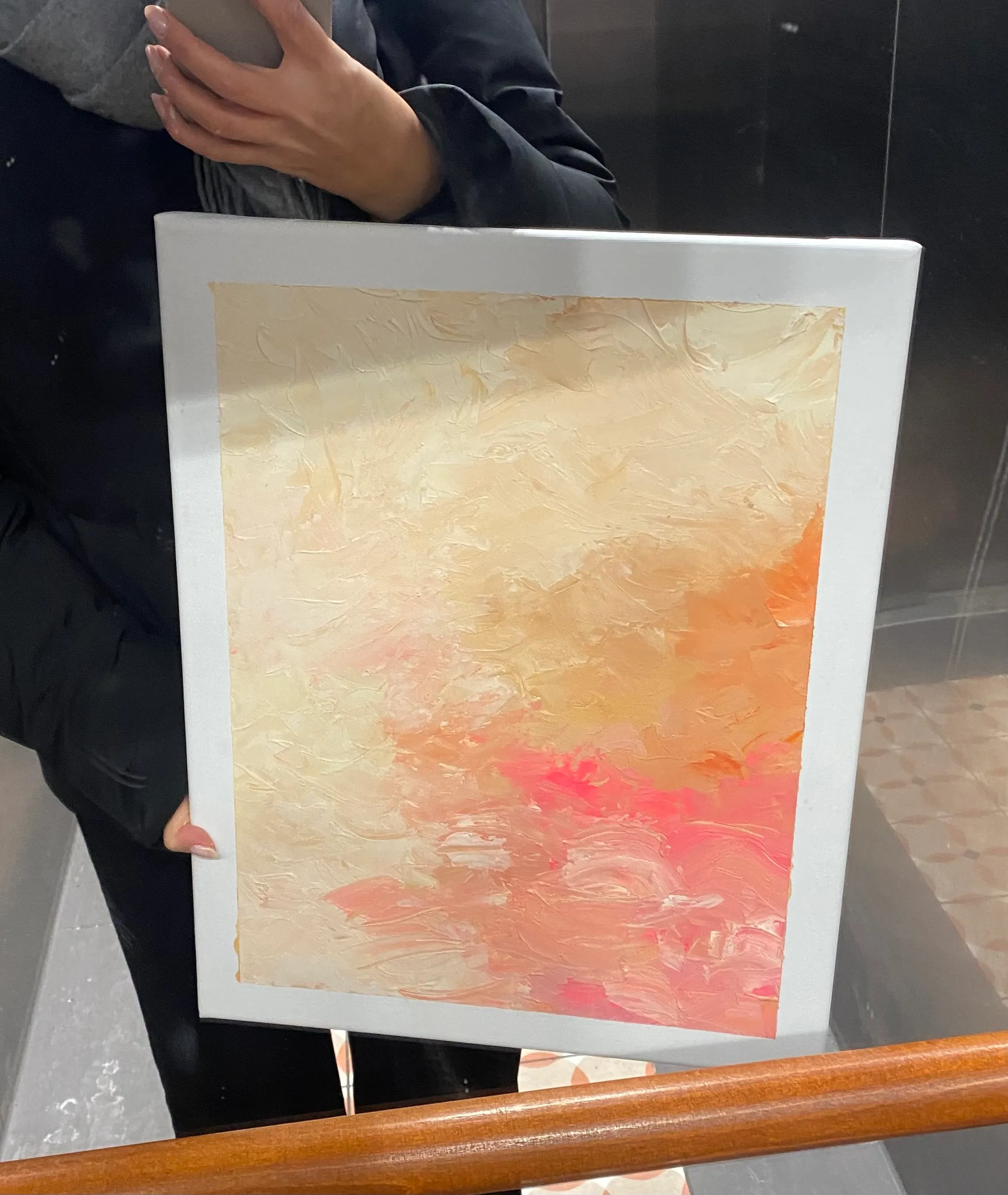 Person hält abstraktes Gemälde im Spiegel.