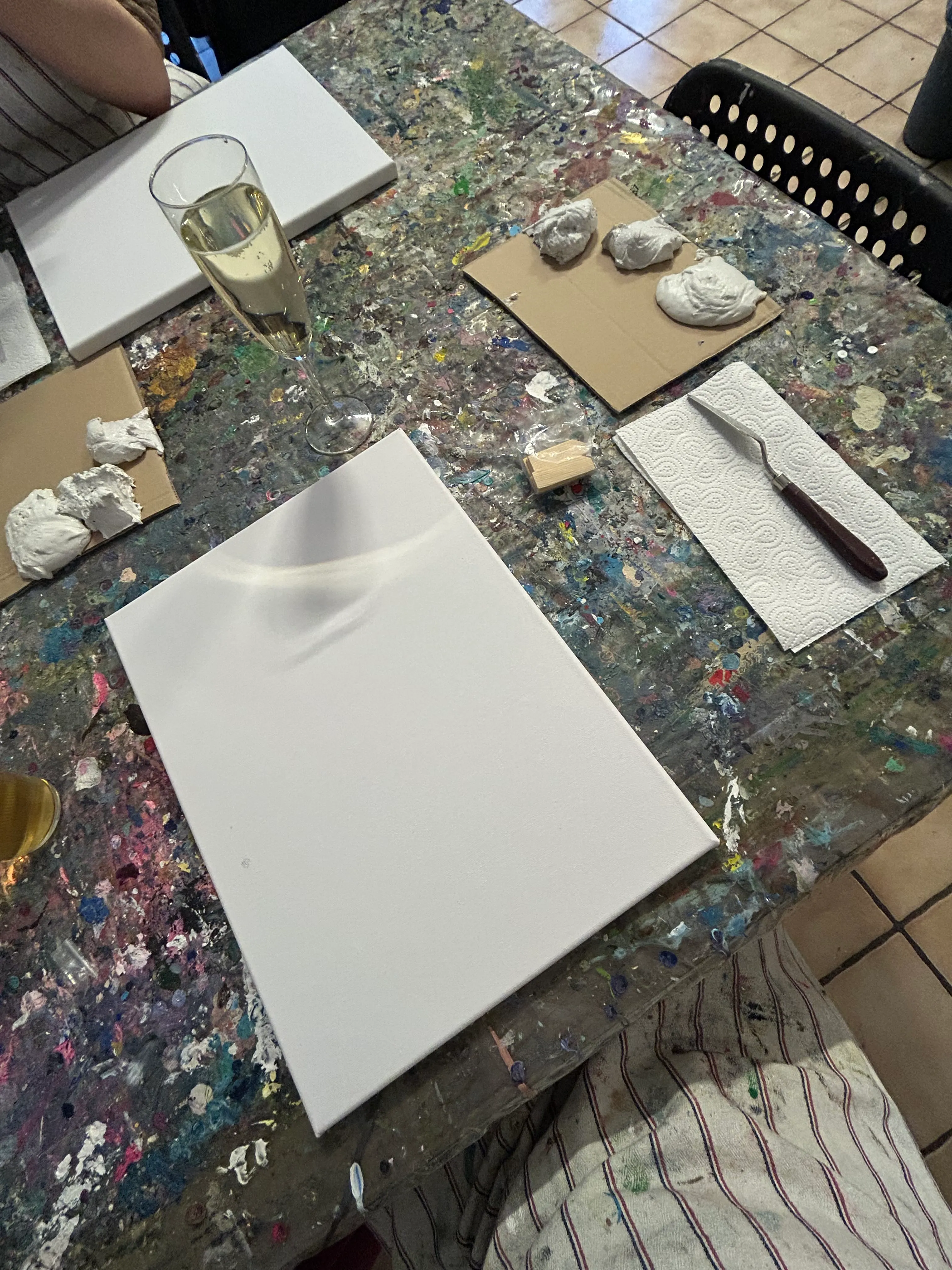 Kunsttisch mit Leinwand, Farbe und Sekt.