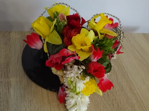Bunte Blumen in zwei Herzformen arrangiert.
