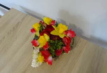 Bunte Blumenarrangement auf Holztisch.