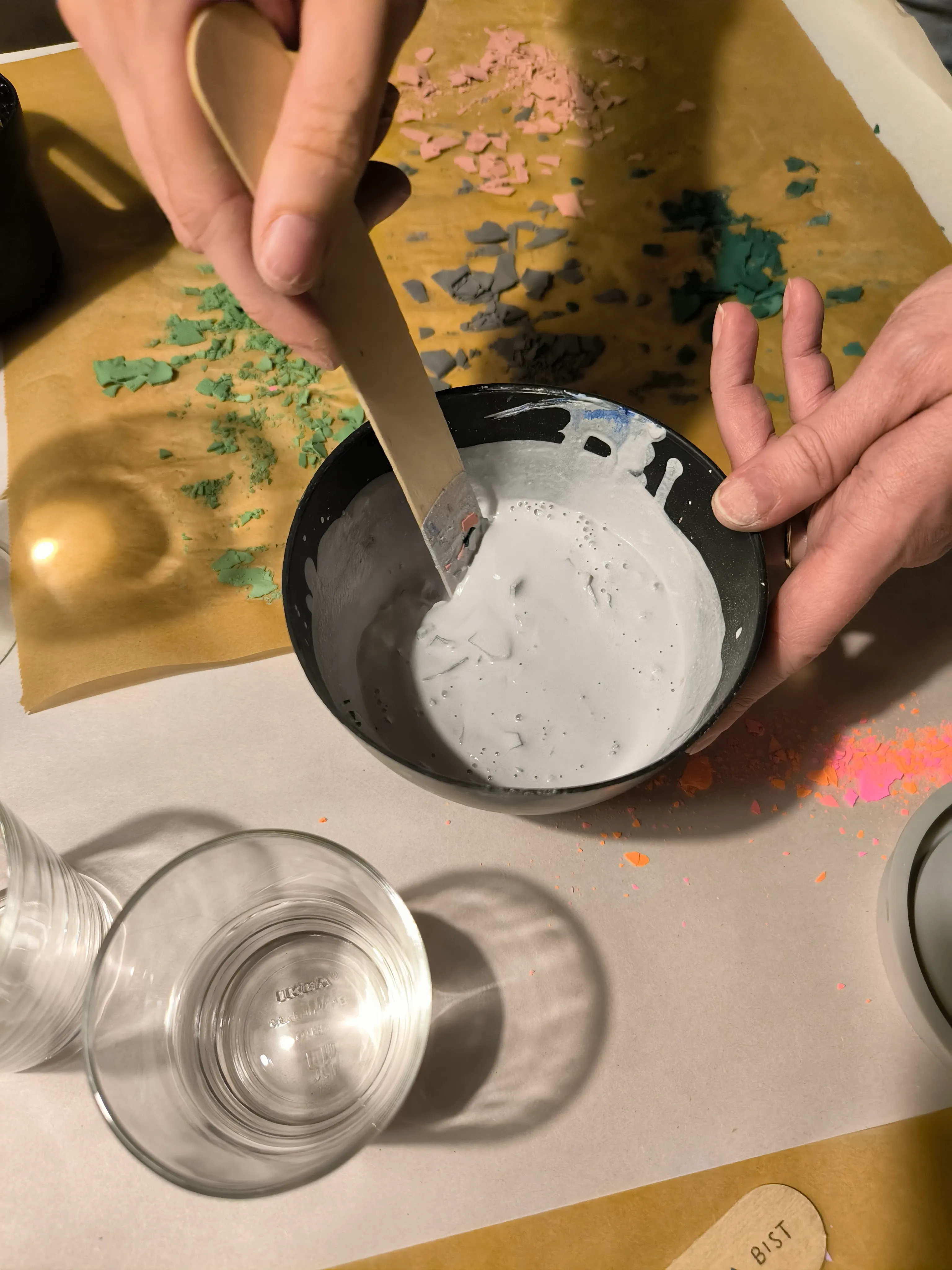 Gips wird mit Holzstab in Schüssel gemischt.