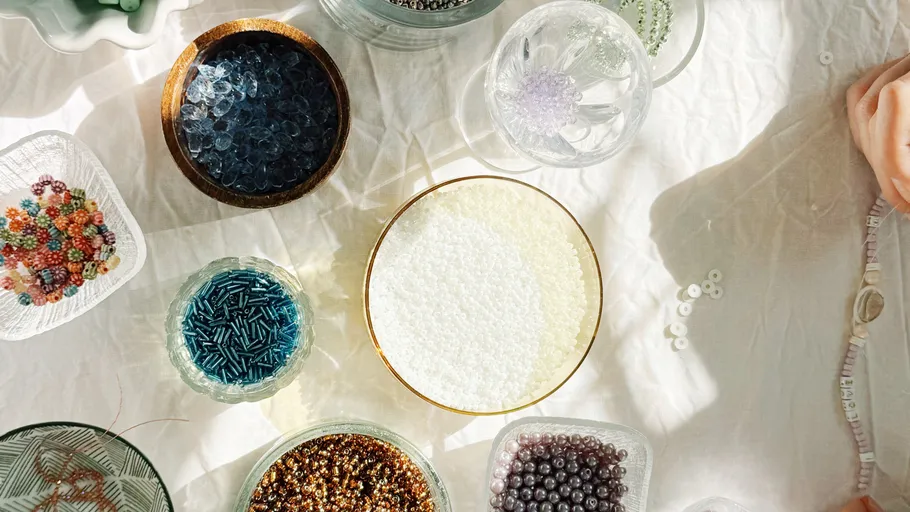 Various beads in containers on a table.