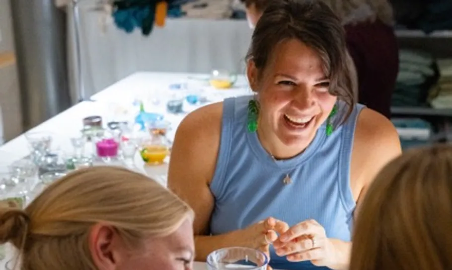 Woman laughing with friends at a table.