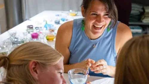 Woman laughing at table with crafts.