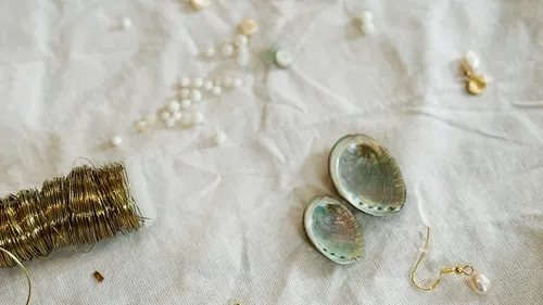 Shells, wire, and beads on fabric surface.