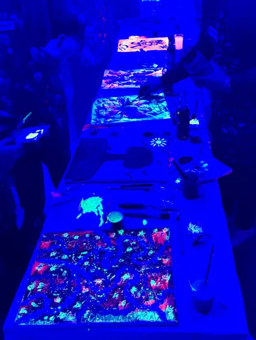 Menschen malen unter blauem UV-Licht.
