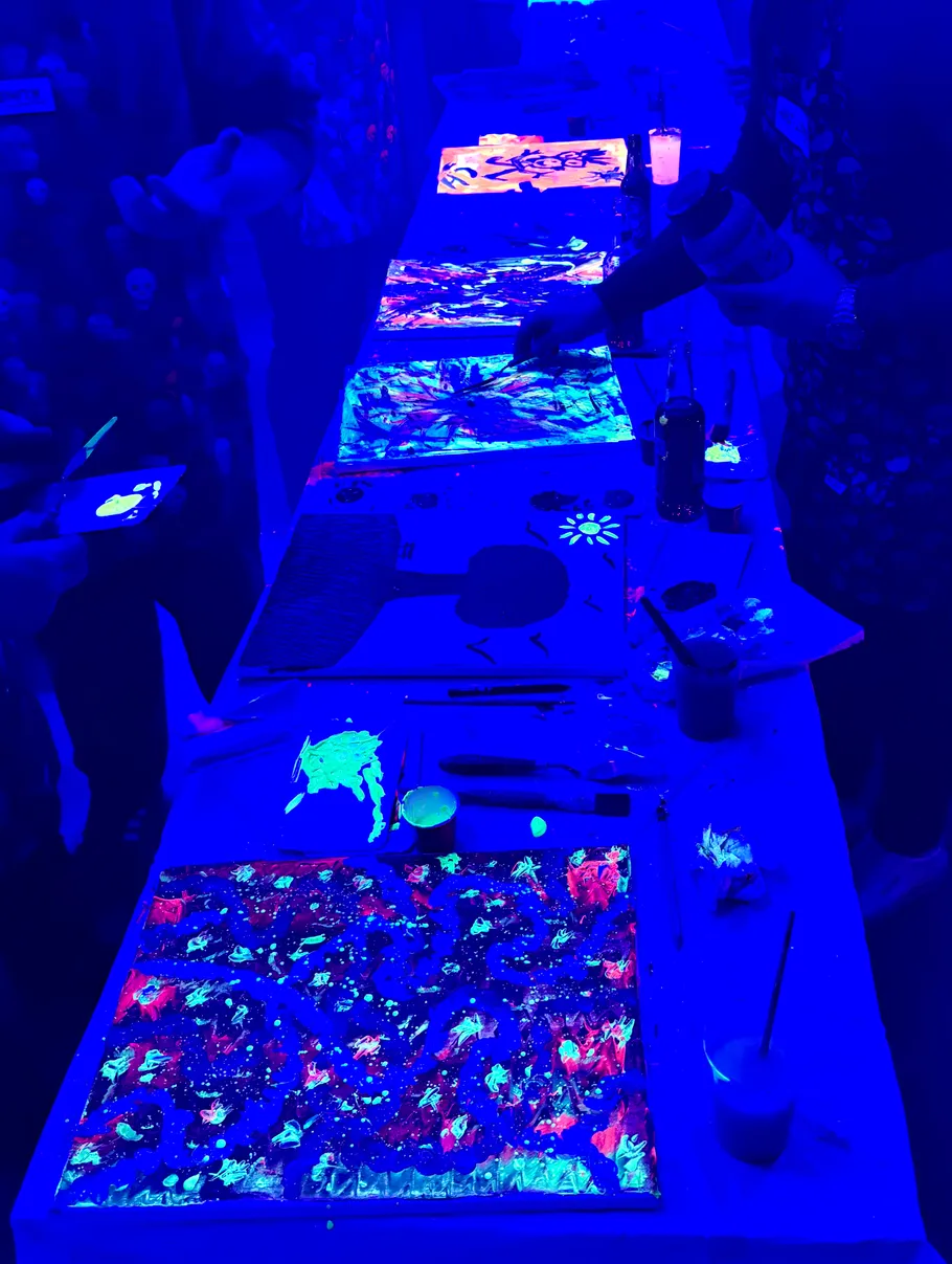 People painting under blue ultraviolet light.