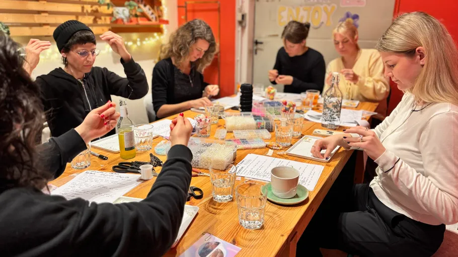 Group crafting at a wooden table indoors.