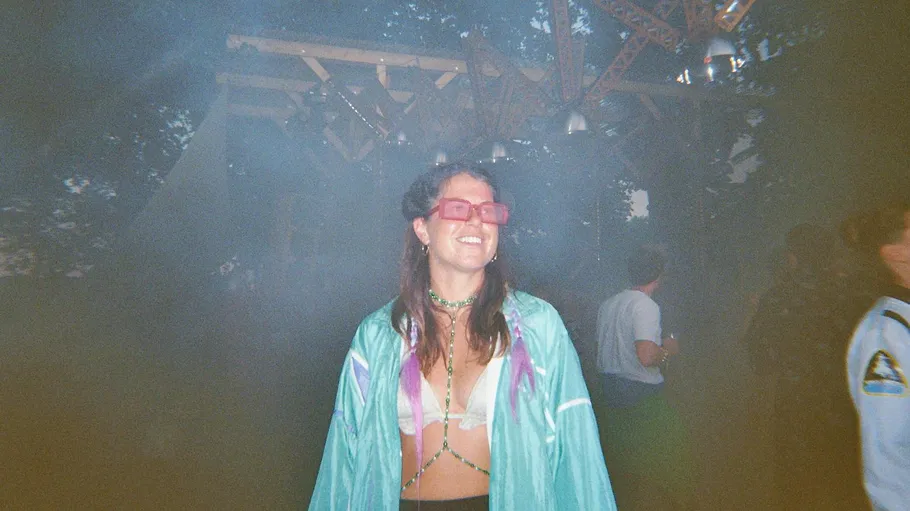 Lächelnde Frau mit Sonnenbrille bei Outdoor-Event.