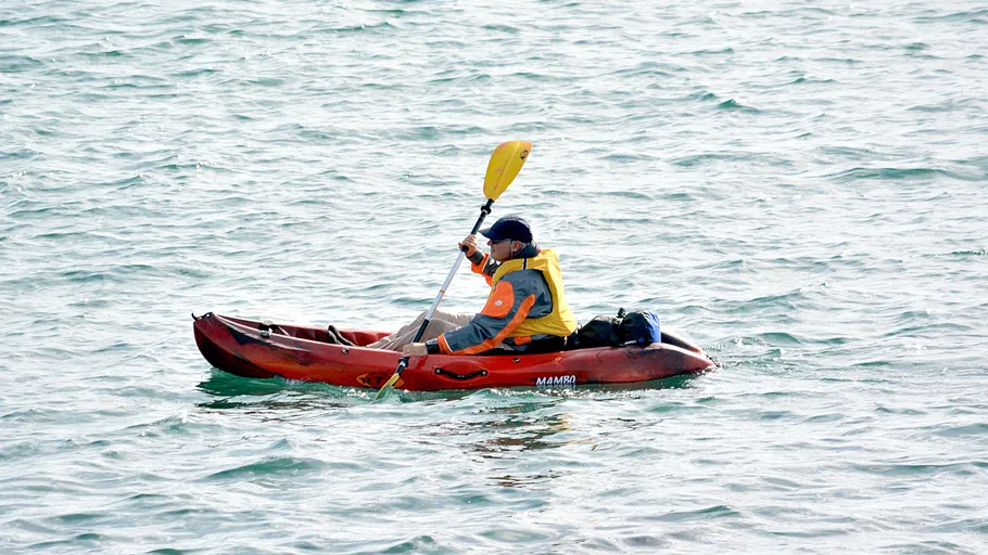 Person beim Kajakfahren auf offenem Wasser.