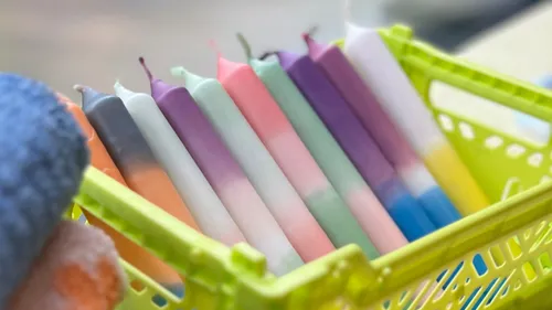 Colorful candles in a green basket.
