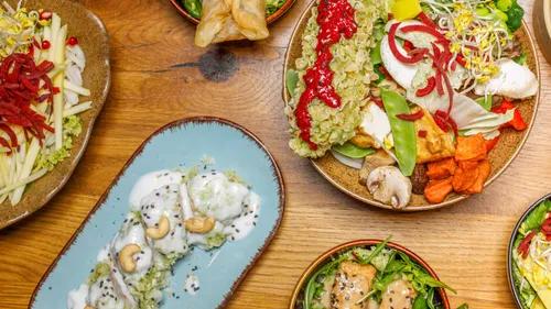 Variety of colorful dishes on wooden table.