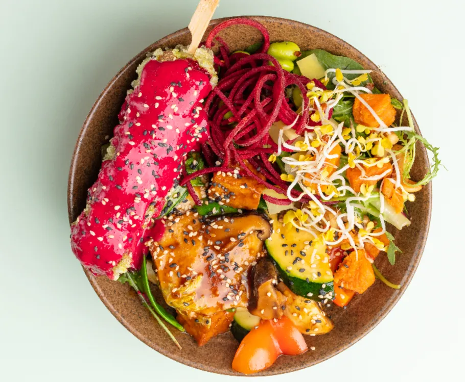 Colorful vegan bowl with vegetables and sauce.