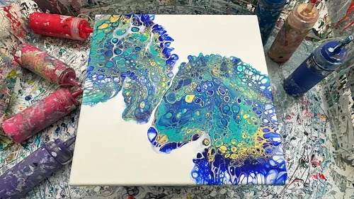 Colorful abstract painting on messy table.