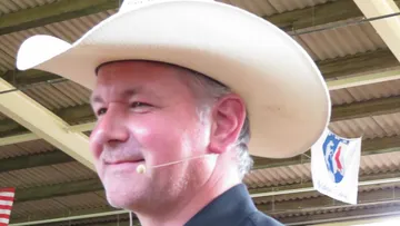 Mann mit Cowboyhut spricht drinnen.