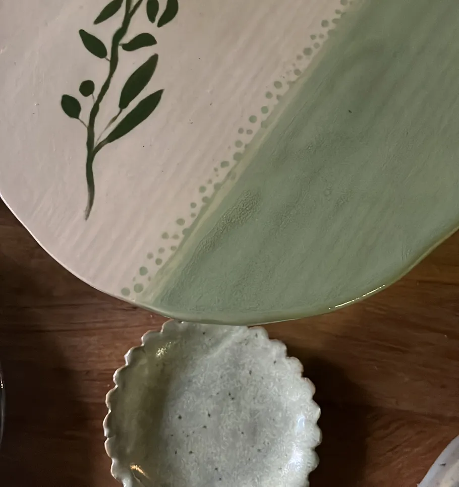 Bemalter Keramikteller mit Blumenmuster.