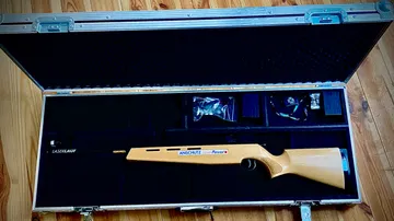 Wooden laser rifle in protective case.
