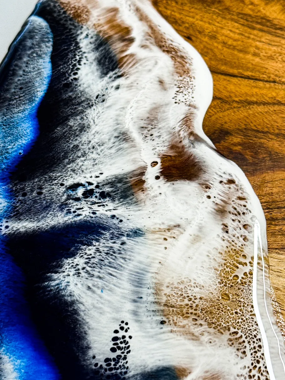 Abstract epoxy art with blue and brown swirls.