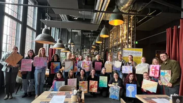 Gruppe hält Kunstwerke in industriellem Restaurant.