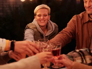 Glasses are raised to toast in good company.