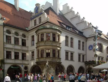 Historisches Gebäude mit Menschen draußen.