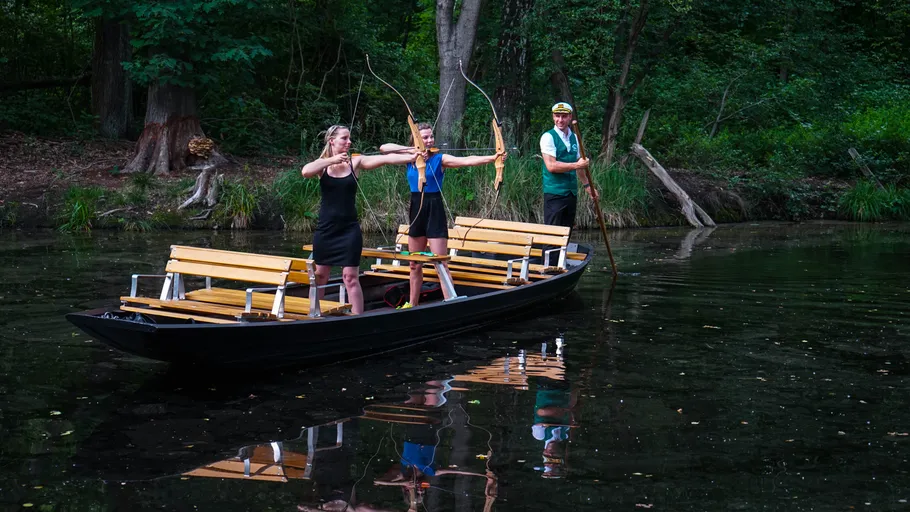 Two women shooting arrows from a boat.