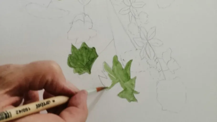 Person painting green leaves on canvas.