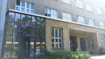 Building facade with windows, trees reflected.