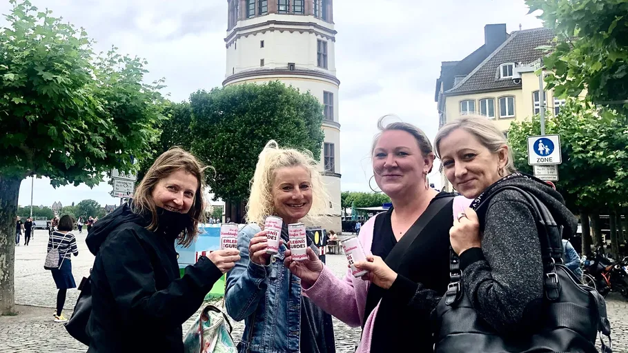 Vier Frauen halten Getränke, im Freien.