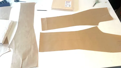 Nähmuster und Werkzeuge auf weißem Tisch.