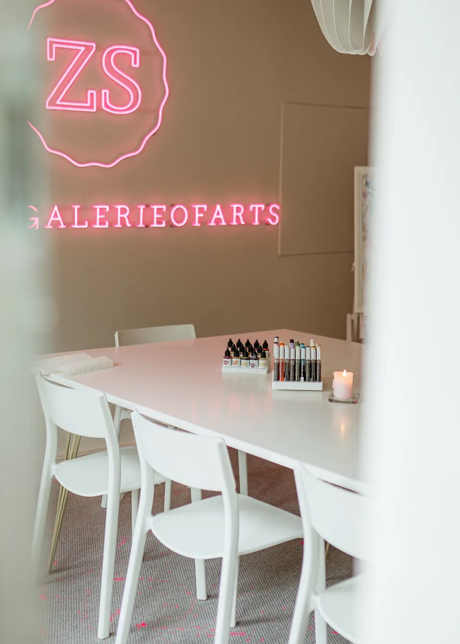 Weißer Tisch mit Kunstzubehör, Neon-Schild.