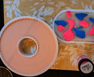Round mold and colorful clay pieces on a table.
