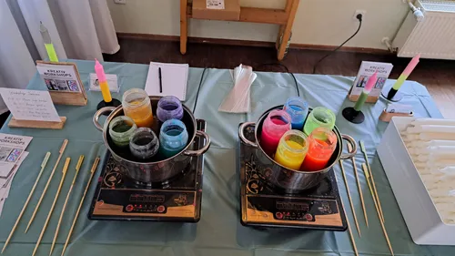 Colored wax jars on stoves for candle making.