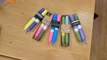 Bunte Kerzensets auf Holztisch platziert.
