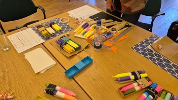 Bastelmaterialien auf einem Holztisch angeordnet.