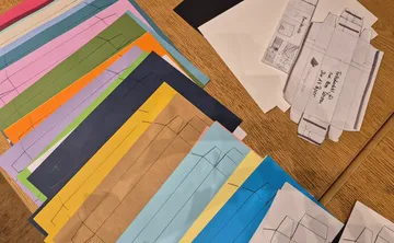 Buntes Papier mit Boxvorlagen auf Tisch.