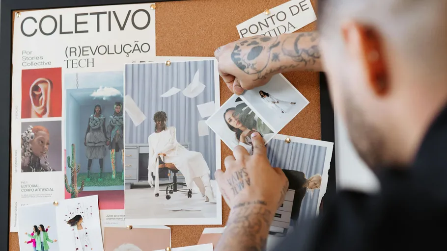 Person pinning photos on bulletin board.