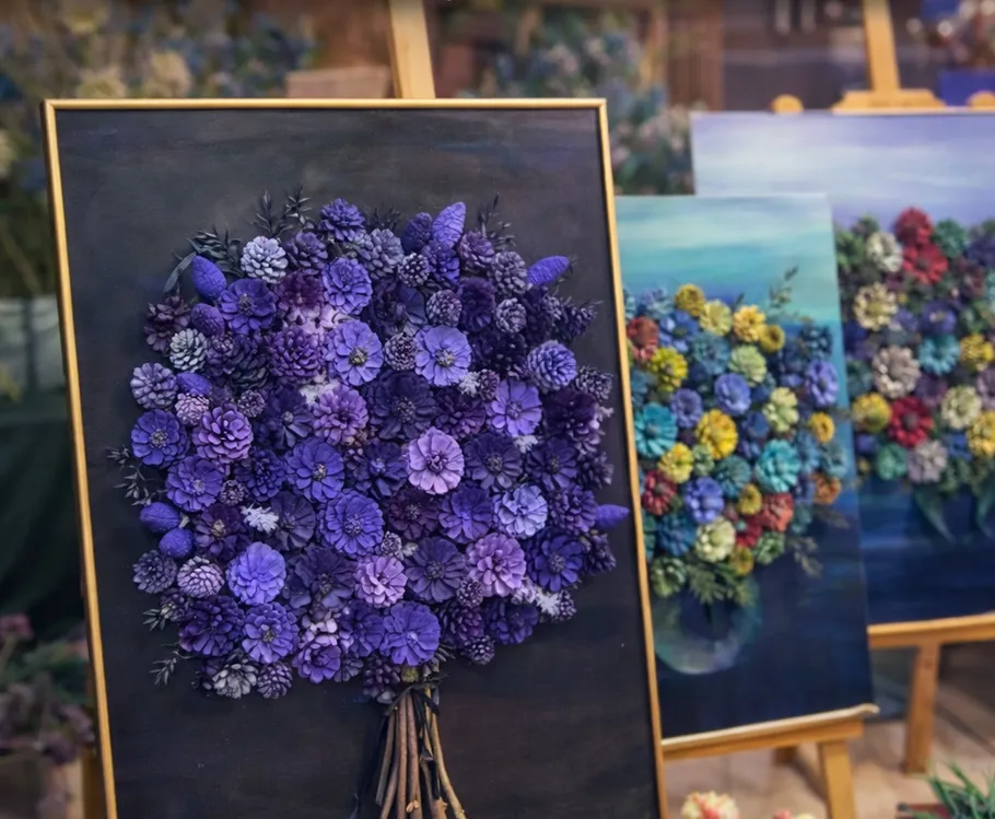 Colorful pinecone art displayed on easels.