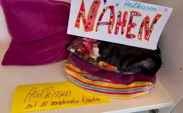 Herbal pillows with sewing sign on shelf.