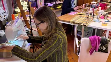 Woman sewing in a craft room.