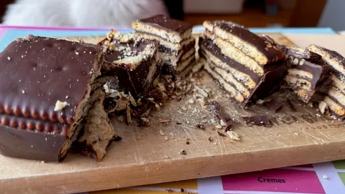 Chocolate biscuit cake sliced on wooden board.