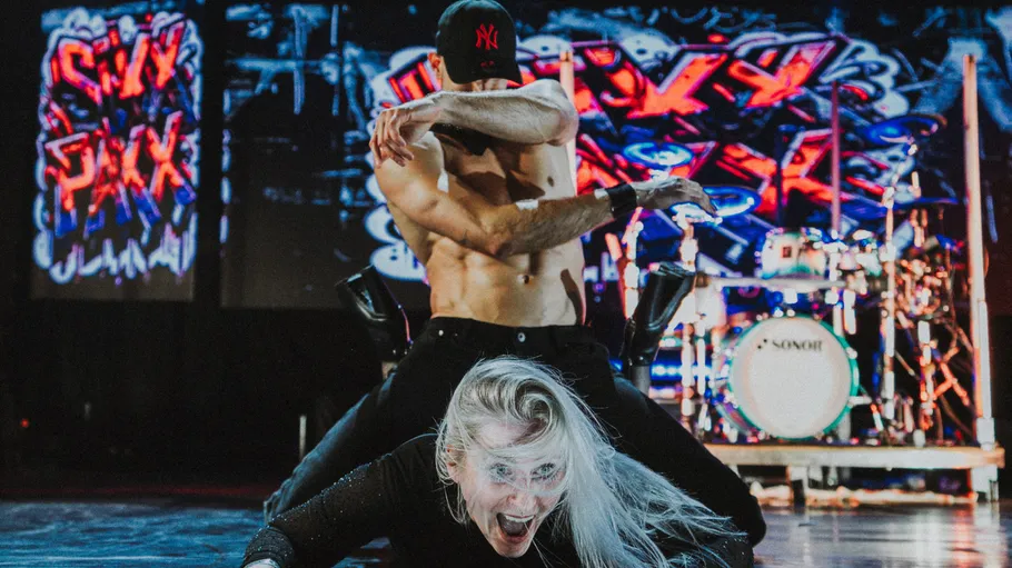 Two energetic dancers perform on stage.