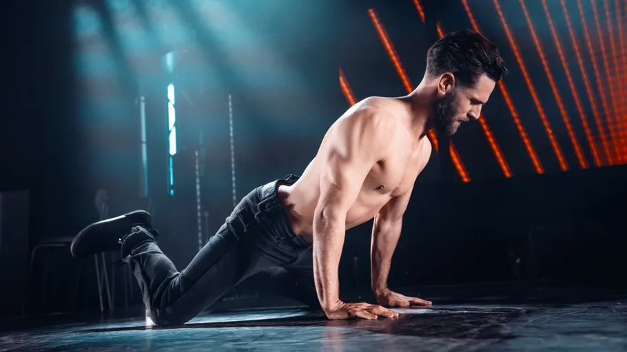 Oben ohne Mann macht Übung auf Bühne.