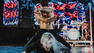 Two dancers performing energetically on stage.
