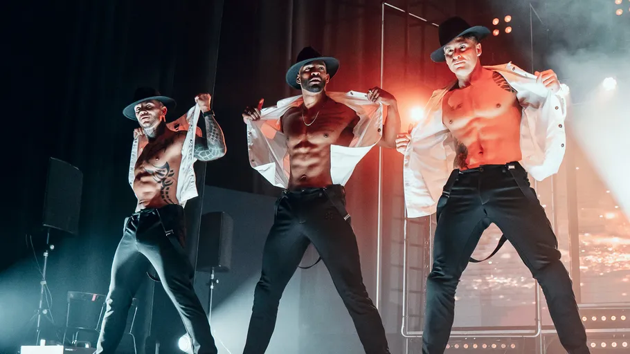 Drei männliche Tänzer auf der Bühne.